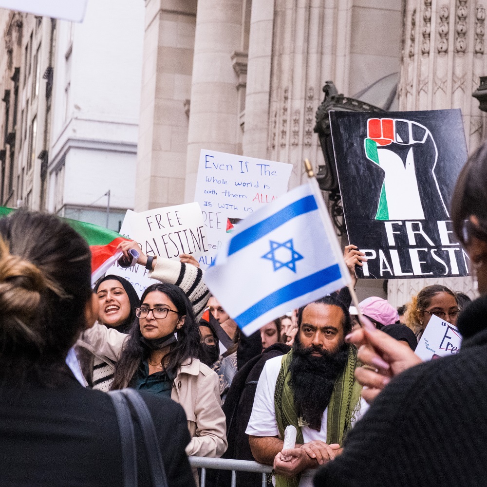 People in meetings holding 'Free Palestine' posters